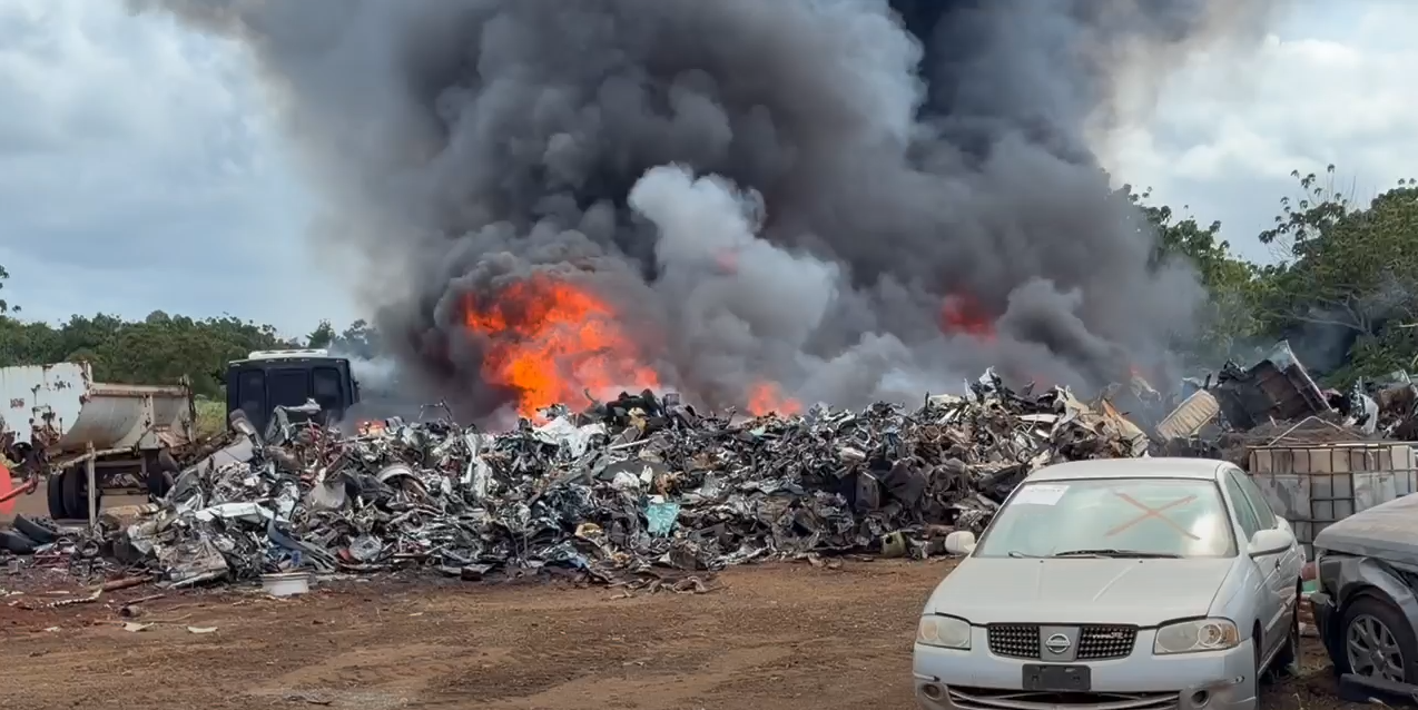 Scrap metal and debris engulfed in flames.