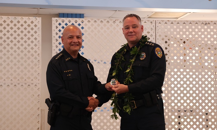 Chief Todd Raybuck (right) presents Interim Chief Elliott Kalani Ke with his badge.