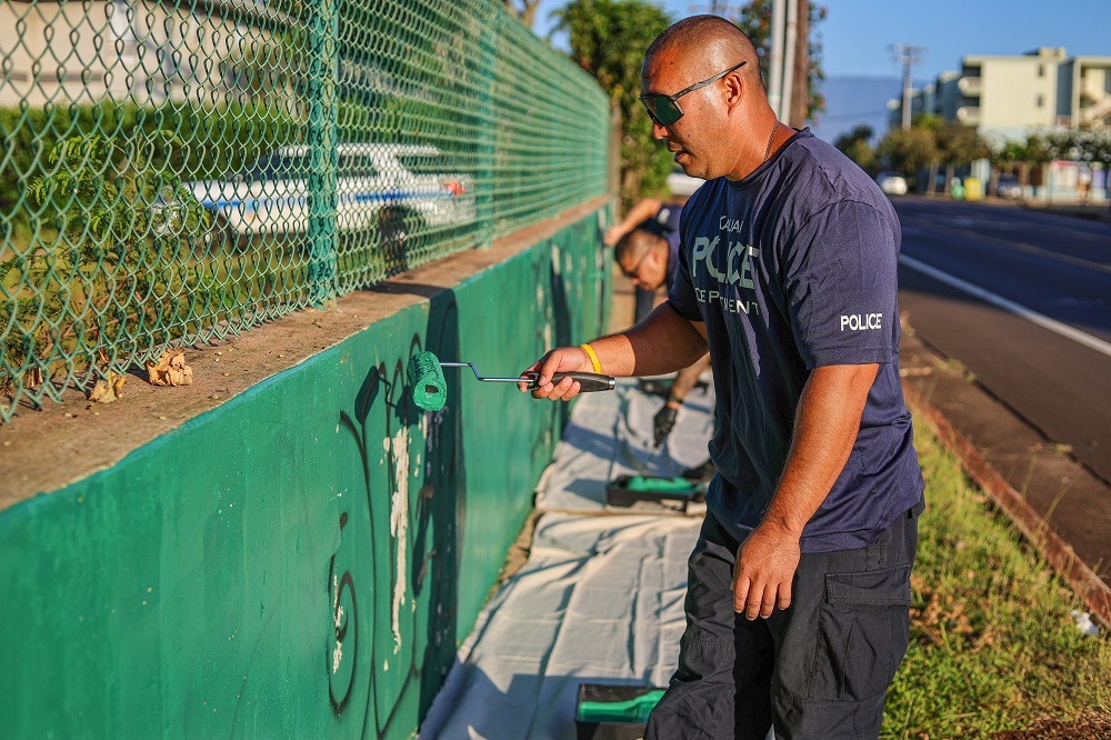 Officers cleaning graffiti