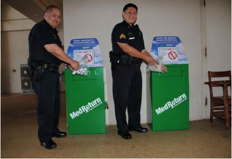 Lieutenant Scott Brede and Sgt. Sandy Wakumoto standing next to Kauai Police Department medication drop boxes