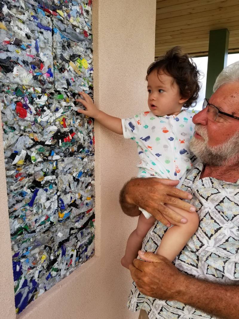 Grandfather and grandson looking at recycled plastic building blocks