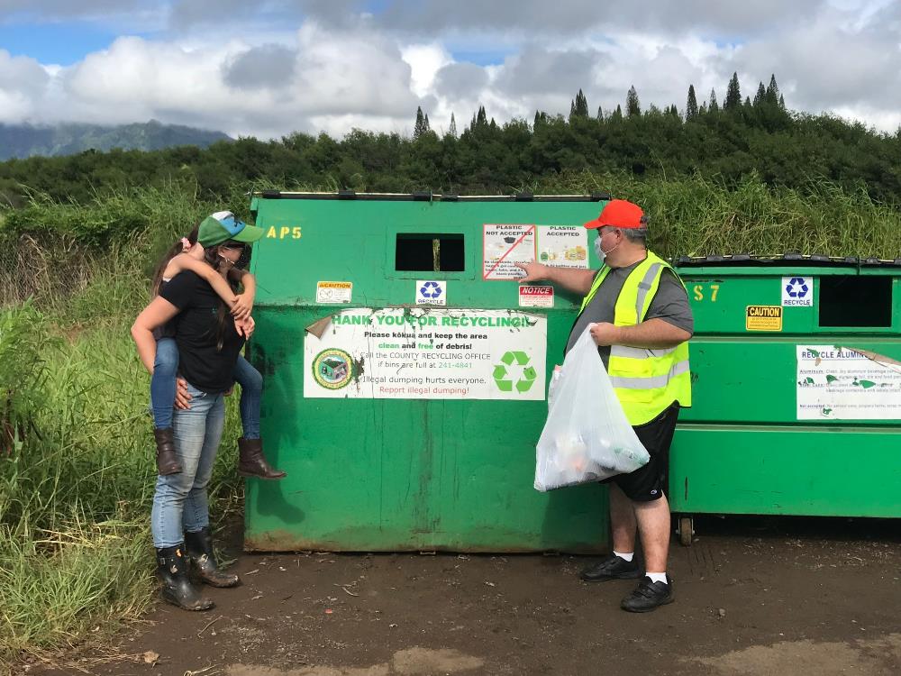 Sarah Dooley, daughter Alana, and Keola Aki of the County at a drop bin